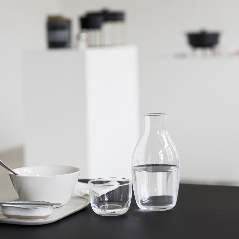 conjunto de jarra y vaso bajo de 75 y 20 cl de vidrio potásico de la colección Passe-partout diseñada por Vincent Van Duysen. Dispuestos en mesa.