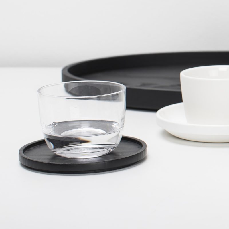 posavasos negro 9 cm diámetro con vaso de agua y otros accesorios de mesa PASSE-PARTOUT en madera de fresno carbonizada