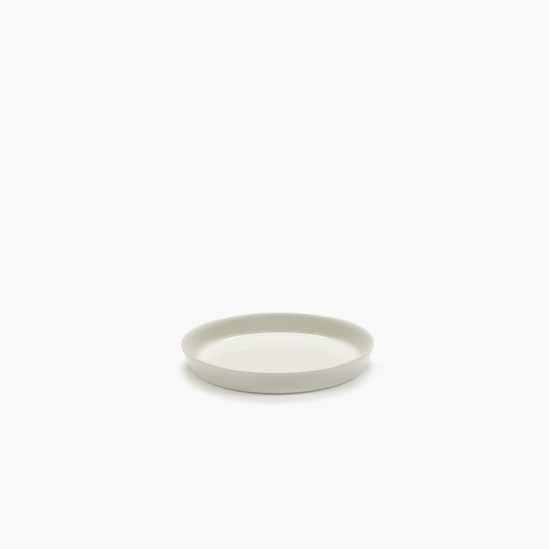 Plato talla XS, muy pequeño, de porcelana, en color marfil CENA diseñado por Vincent Van Duysen. Vista con aire.