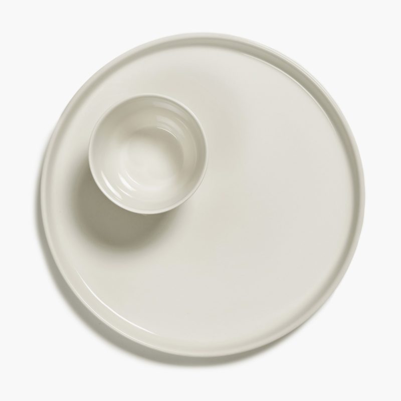Plato talla L grande y taza, de porcelana, en color marfil CENA diseñado por Vincent Van Duysen. Vista con aire.