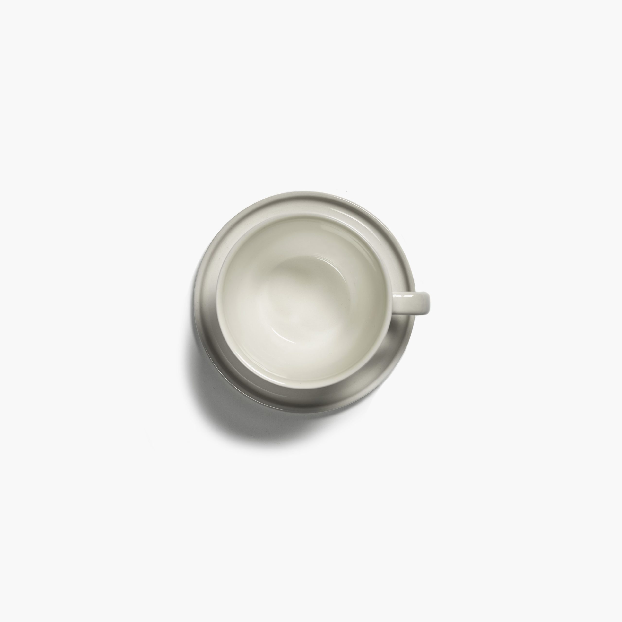 platillo y taza para cappuccino, de porcelana, en color marfil CENA diseñados por Vincent Van Duysen. Vista cenital.