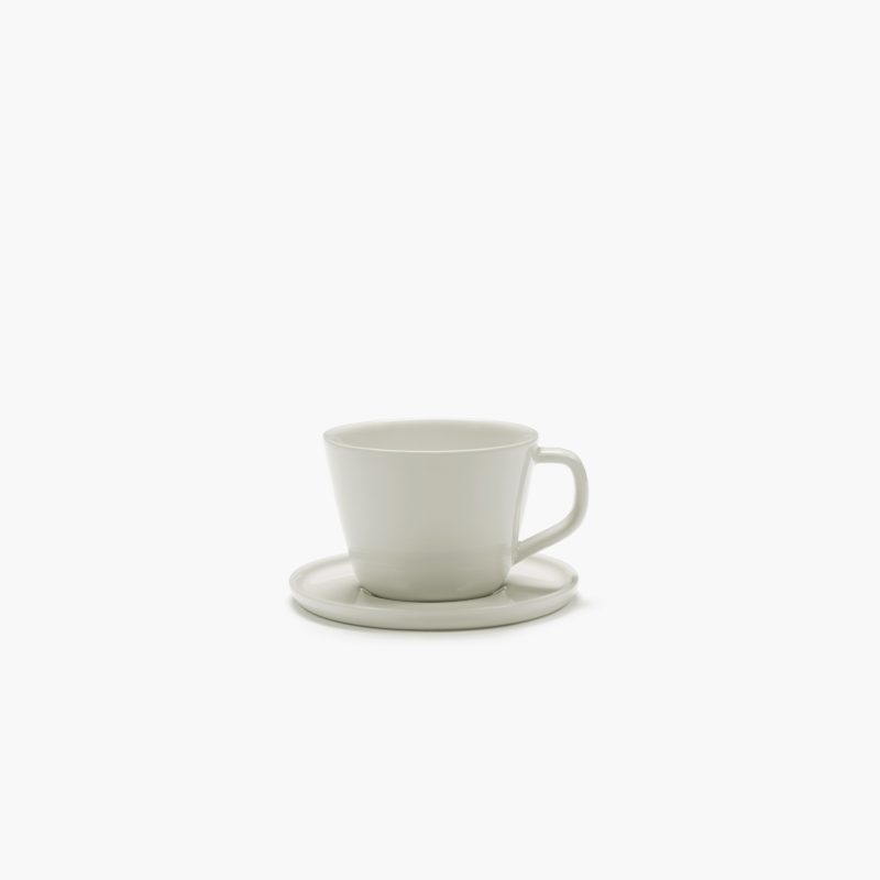 platillo y taza para cappuccino, de porcelana, en color marfil CENA diseñados por Vincent Van Duysen. Vista con aire.